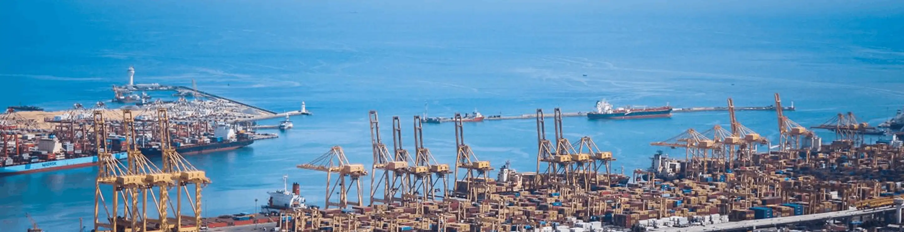 Container port with cranes loading cargo at sunset